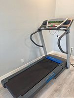 Full view of treadmill showing frame, belt, handrails, foldable deck