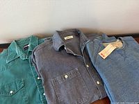 Three tops laid flat showing overall styles and colours