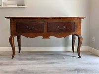 Front view showing two drawers, cabriole legs and scalloped apron