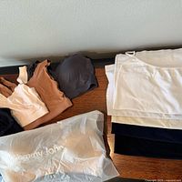 All bras, bralettes, camisoles and sealed bag displayed on table