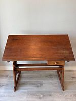 Front view of drafting desk showing tilting wood top and drawer