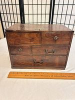 front view of wooden sewing box showing drawer arrangement and hardware