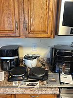 All five appliances arranged on counter showing overall condition, manuals visible