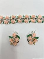 Front view of bracelet and earrings showing floral enamel detail