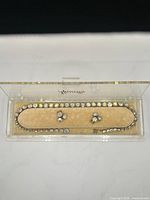 Full view of necklace and both earrings in clear display case marked Weiss