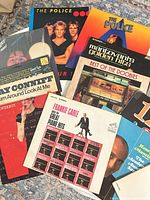 Stack of LP records showing covers: The Police, Mantovani, Best of the Doobies, Loverboy, Ray Conniff, Frankie Carle etc.