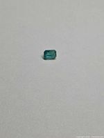 Loose octagon-cut emerald on neutral background