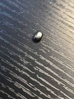 Top view of oval black star sapphire showing body colour and star effect