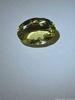 Oblique view of oval faceted lemon citrine showing color and facet arrangement