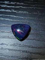 Trillion cabochon black opal front view showing play-of-color