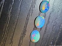 Three opal cabochons on textured background