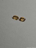 pair of oval golden citrine gemstones on neutral background