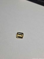 Emerald-cut golden heliodor on neutral background