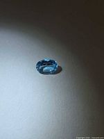 Top view of oval blue topaz on neutral background