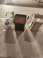 Three items: two ceramic wax warmers and bagged Maple Leafs night light on table