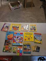 Overhead view of all books, flash card box and trading cards on table