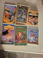 Front covers of all six Disney VHS tapes arranged on table