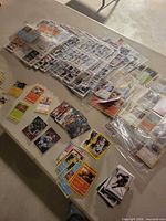 Overall view of multiple stacks and binder pages of assorted trading cards on table