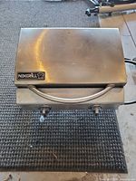 Closed view of stainless steel Nexgrill tabletop propane grill with twin control knobs