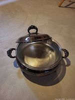 chafing dish opened showing glass insert and ornate handles