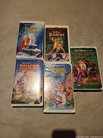 Front view of the five Walt Disney VHS tapes laid out, showing cover art and titles