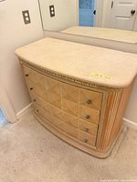 Front view of dresser showing overall design, diamond veneer fronts, carved sides, stone-look top