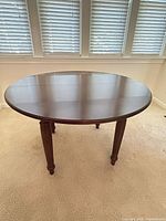 Full view of round wooden dining table with dark finish