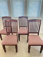 Four of the five matching wooden dining chairs front view
