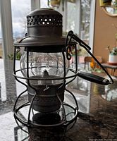 Front view of Adlake metal lantern showing globe and vent top