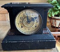 Front view of mantel clock showing dial, bezel and case detail