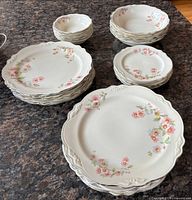 Stacked assortment of plates and bowls showing pattern and quantity