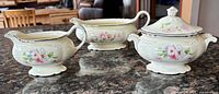 Group image showing creamer, lidded sugar bowl and gravy boat, floral pattern visible