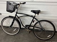 Full view of black Norco cruiser bicycle with basket