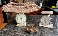 Overall view showing Pelouze scale with wicker basket, American Family scale, and brass balance scale with weights