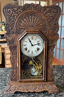 Front view of carved oak Sessions mantel clock