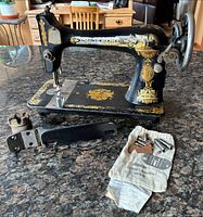 Overall view of Singer sewing machine with accessories on countertop