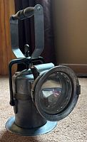 Front angled view showing lens, body, handle and base