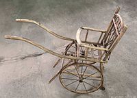 Side view of entire wooden rickshaw cart showing wheels, seat, handles and finish