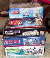 Stack of five Wrebbit Puzz-3D boxes showing titles and themes