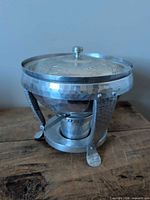 Full view of hammered aluminum chafing dish assembled with lid, stand, and burner