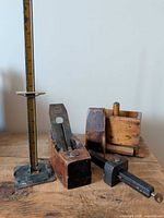 Group shot of all four items: bench plane, height gauge, marking gauge, butter press