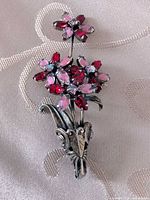 Front view of silver-tone floral brooch with red and pink rhinestones