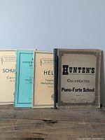 Front covers of four piano books lined in a row