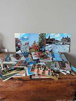 Stacks of assorted postcards spread on wooden surface