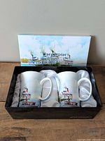 Box opened showing two bone china mugs inside satin lining
