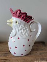 Left side profile of rooster pitcher showing handle and polka dots