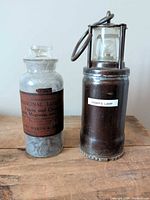Miner's lamp and apothecary jar side by side