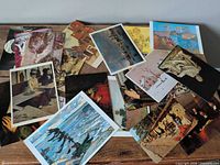 Assortment of art postcards and prints spread on table