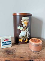 All three tins grouped: Rexall Quik-Bands, Sarah Kay cylinder, Norman Rockwell round tin