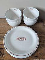 Stack of four bowls and four plates showing logo and rim design